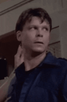 a man in a blue jacket is being touched by someone