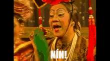 a woman in a costume says nin while holding a green object