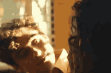 a man and a woman are looking at each other in a room .