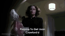 a woman is holding a doll and says " prepare to get joan crawford "