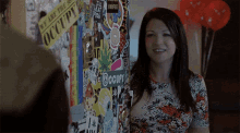 a woman is standing in front of a wall with stickers on it and one of them says occupy