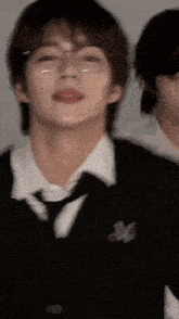 a close up of a person wearing glasses and a tie .