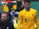 a soccer player wearing a yellow shirt that says standard chartered on it