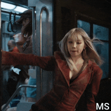 a woman in a red jacket is standing in a doorway with the letters ms below her
