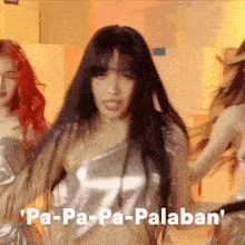 a woman with long black hair is dancing in front of a sign that says ' pa-pa-pa-palaban ' .