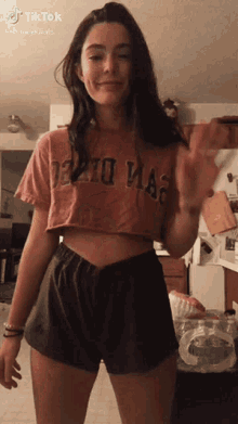 a girl wearing a crop top that says ' detroit mag ' on it