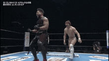 two men are wrestling in a ring and one of them is holding the other 's arm .