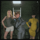 three women standing next to each other in a room with a sign that says " emergency exit "