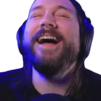 a man with a beard wearing headphones is laughing with his mouth open