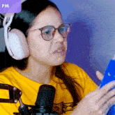 a woman wearing headphones and glasses is looking at a cell phone with a purple border that says pm