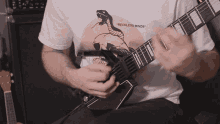 a man is playing a guitar with a shirt that says reckless minds