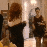 a woman in a black dress stands next to another woman in a black dress