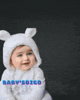 a baby wearing a white bunny costume with the words baby 's digo beneath it