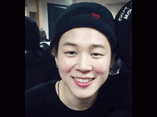 a person wearing a black hat with a red heart on it