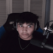 a blurry picture of a man wearing headphones pointing