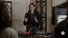 a man standing in front of a turntable with a w logo on the bottom right