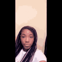 a girl with braids is taking a selfie with her phone .