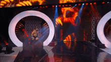 a wrestler is walking down a stage with the word new on the bottom left