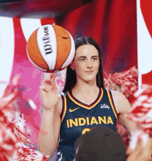 a woman in an indiana jersey is holding a basketball