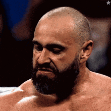 a shirtless man with a beard looks down with a star in the background
