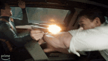 two men are fighting in a car with the word prime on the bottom left