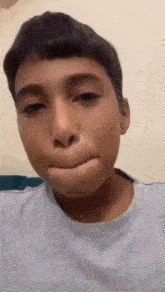 a young boy is making a funny face while wearing a white t-shirt .