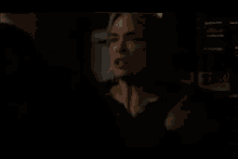 a woman in a black shirt is standing in front of a shelf with boxes of cigarettes on it