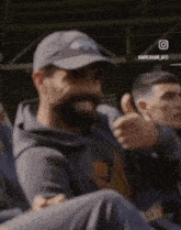 a man with a beard is giving a thumbs up in a crowd
