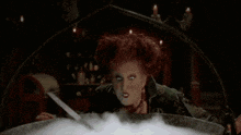 a witch is in a cauldron with green smoke coming out of it and the word ho is visible