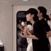 a group of young men are standing next to each other in front of a door .