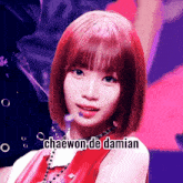a girl with red hair and the name chaewon de damian on her face