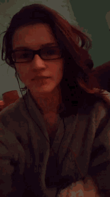 a woman wearing glasses and headphones is making a gesture with her hands