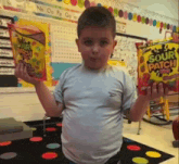 a young boy is holding a bag of sour patch candy