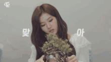 three women are sitting at a table with potted plants and a sign that says to