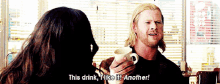 a man is holding a cup of coffee and saying this drink i like it another