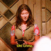 a woman in a floral shirt is holding a cell phone and saying oh crime