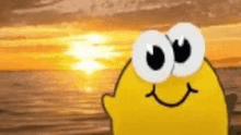 a yellow cartoon character with big eyes and a smiling face is standing on a beach .