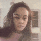 a close up of a girl 's face with a pink shirt on .