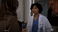 a woman in a lab coat is talking to another woman with #svu written below her