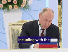 a man sitting at a table with a sign that says including with the on it