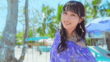 a woman in a purple dress is smiling in front of palm trees