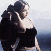 a woman in a black crop top and jeans is standing in front of a man .
