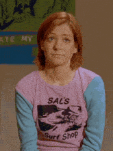 a woman is wearing a purple shirt that says sal 's surf shop
