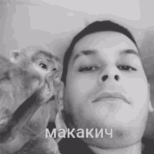 a black and white photo of a man and a monkey with the word makakich written on his face