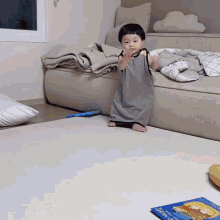 a baby is standing on a rug next to a book called night