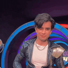 a young man in a leather jacket and white shirt is smiling