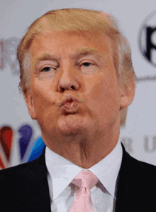 donald trump is wearing a pink tie and making a kissing face