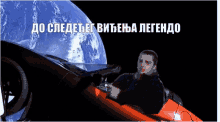 a man is sitting in a red car in front of a planet