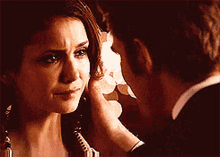 a man is touching a woman 's face with his hand .