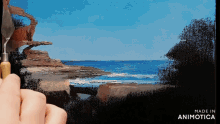 a person is painting a picture of the ocean with the words made in animotica on the bottom